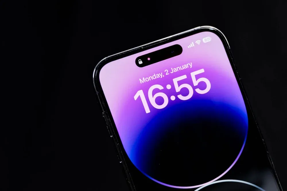 Smartphone with a glowing purple screen on a black background